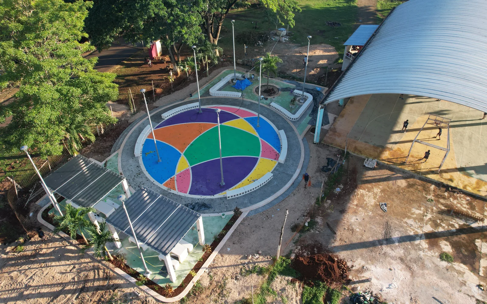Vista aérea de un parque público construido por Braymar, con plaza circular, domo y cancha